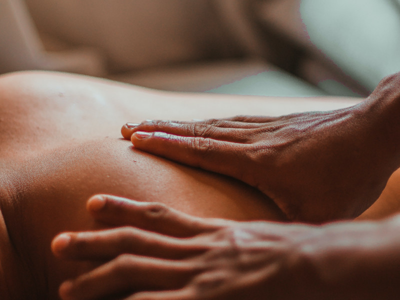 Hände massieren Arm und Achselbereich